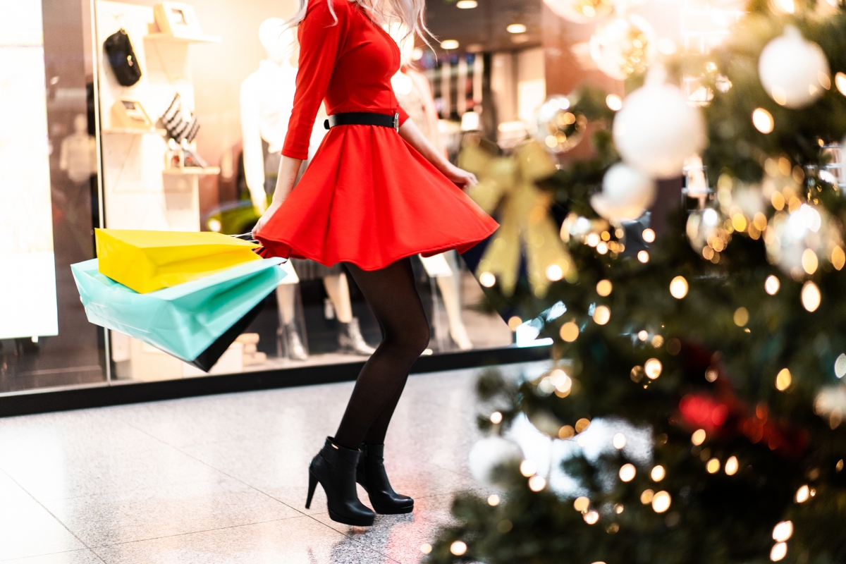 穿红裙子黑色丝袜的女人享受圣诞购物高清图片